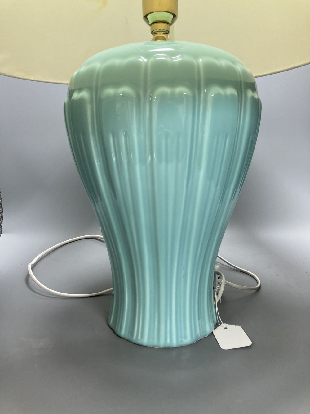 A pair of celadon glazed table lamps, with shades, overall height 63cm